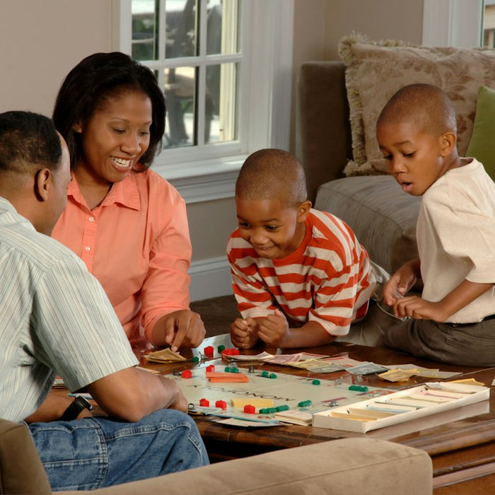 Familia jugando un juego de mesa junta en casa