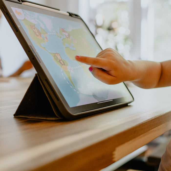 Niña practicando código educativo en una tablet como parte de su tarea