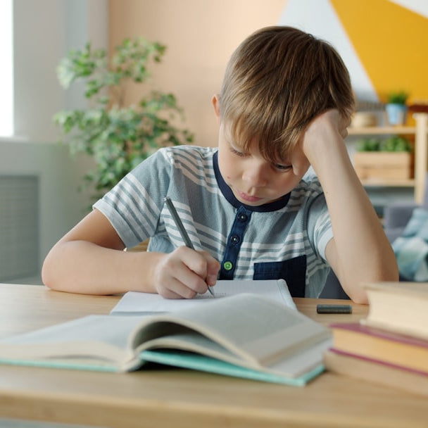 Niño concentrado haciendo la tarea en su escritorio en casa